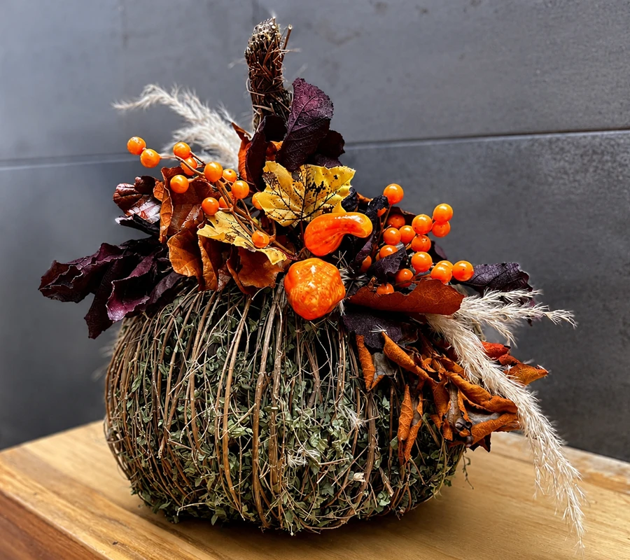 Calabaza floral con bayas naranjas y hojas de otoño