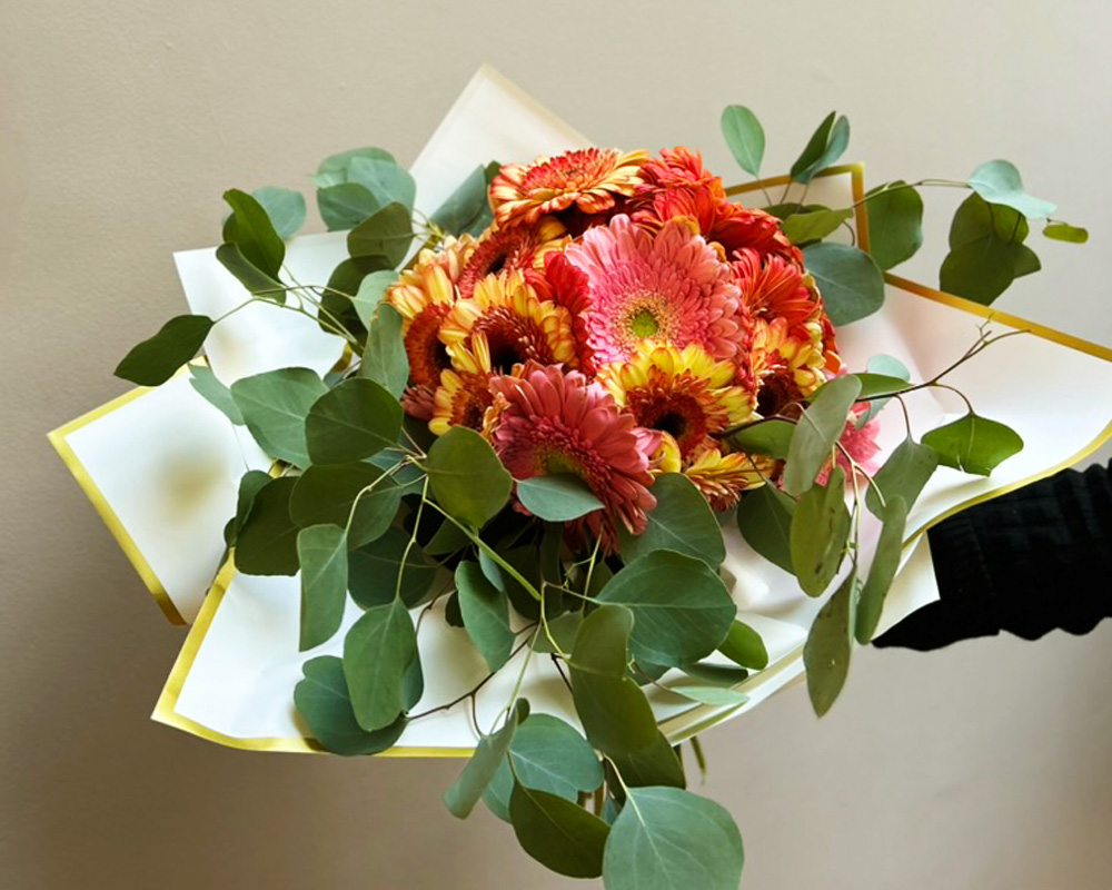 Bouquet floral listo para venta con gerberas en tonos cálidos