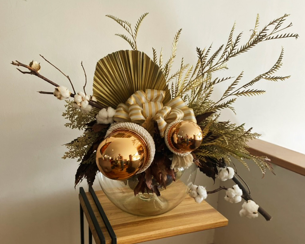 Arreglo floral decorativo en base de vidrio dorado