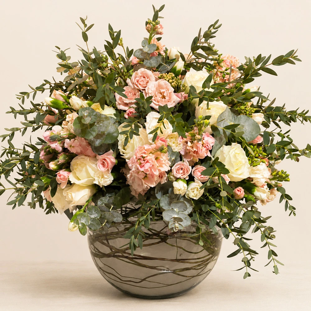 Arreglo floral artesanal en tonos rosa y blanco dentro de un florero