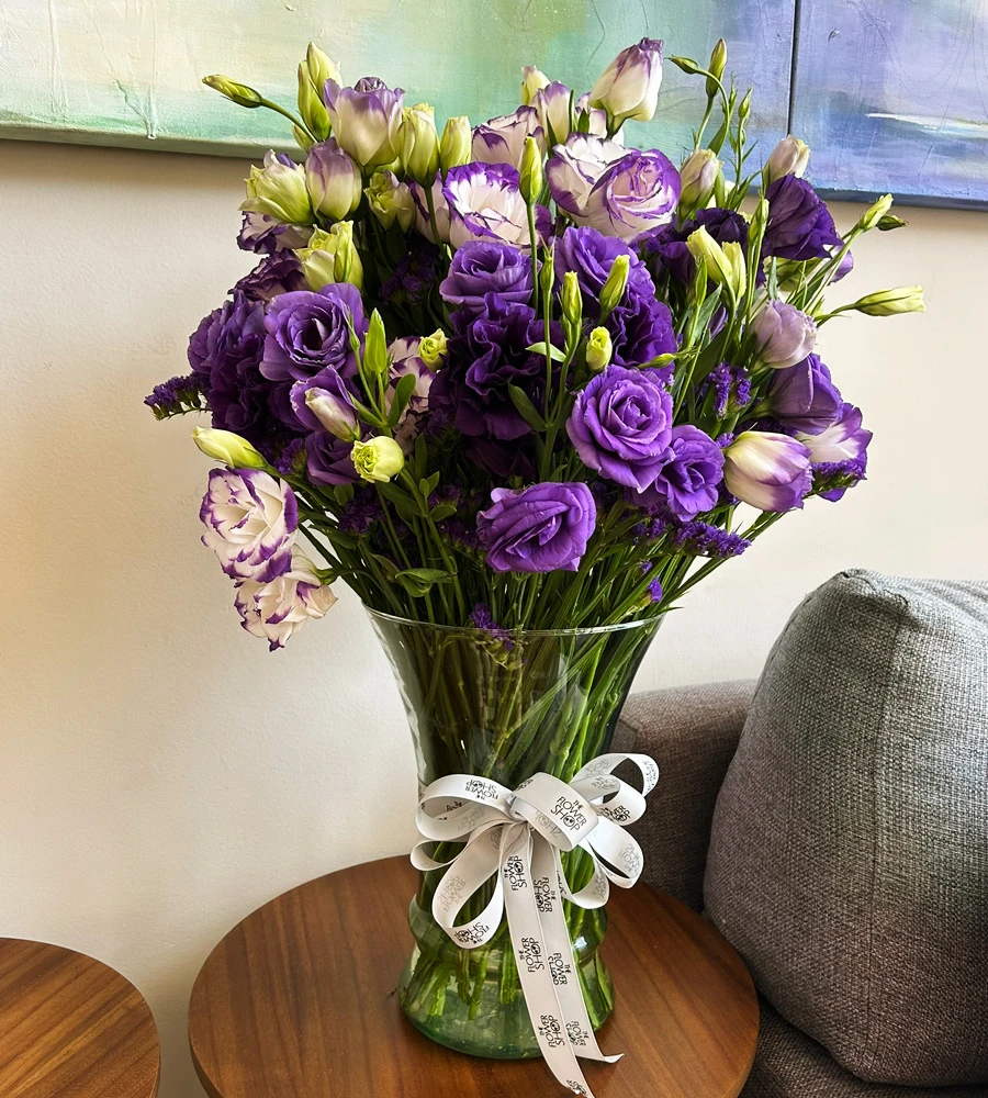 Arreglo floral morado con lisianthus en florero de vidrio