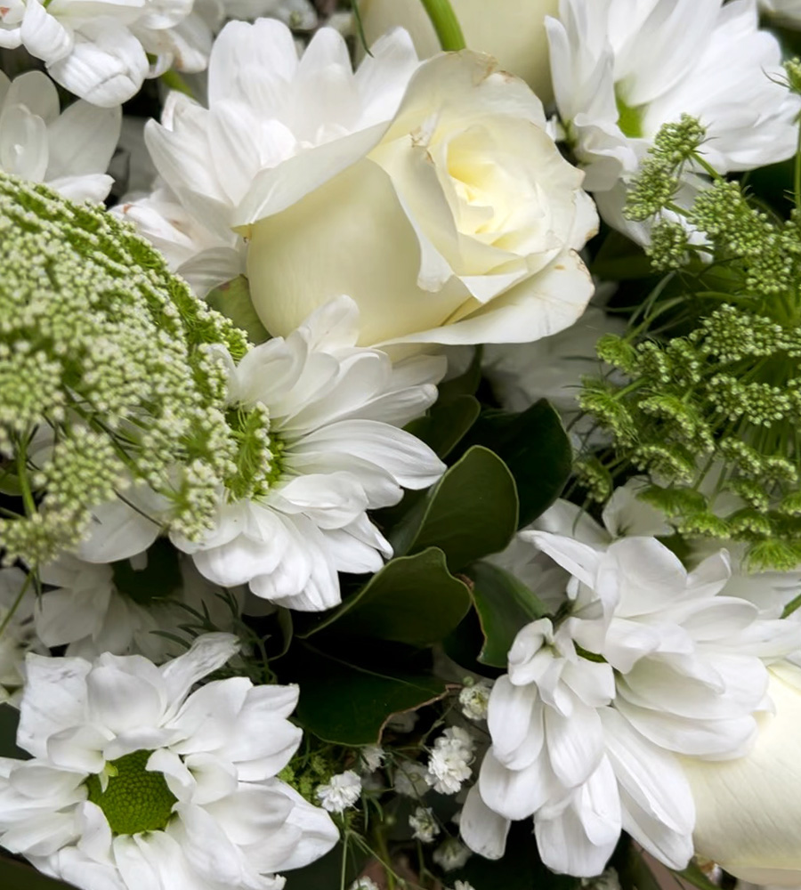 Arreglo floral blanco con rosas, crisantemos y follaje verde