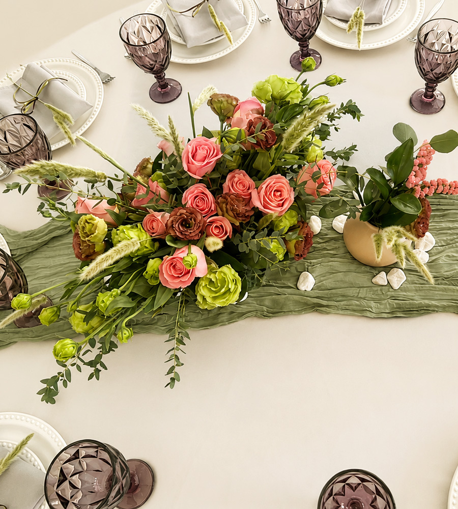 Centro de mesa floral elegante con rosas rosadas y follajes verdes